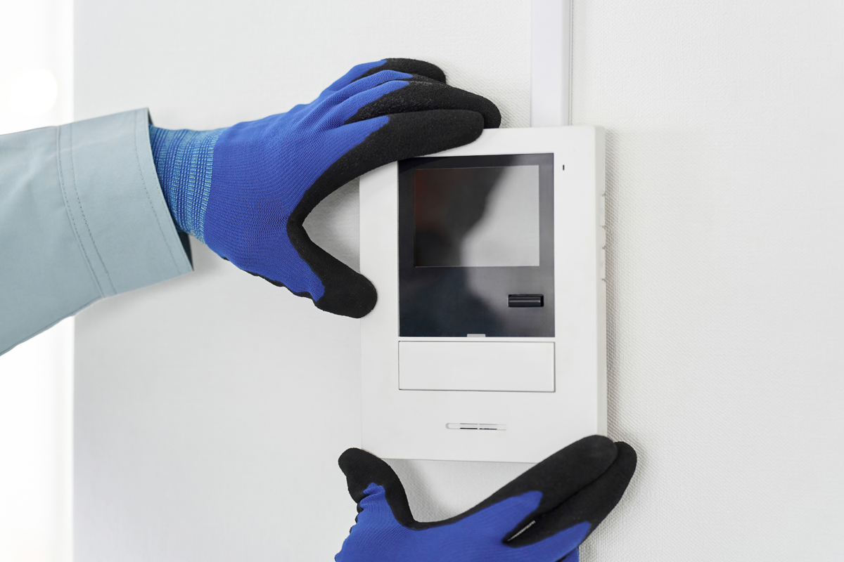 An electrician installing an intercom monitor