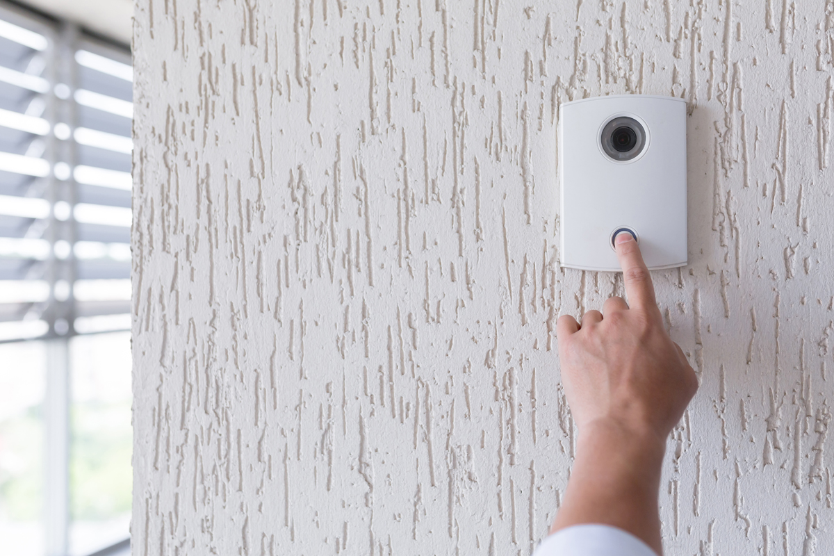 Hand of a man in a white shirt pressing the button of a door